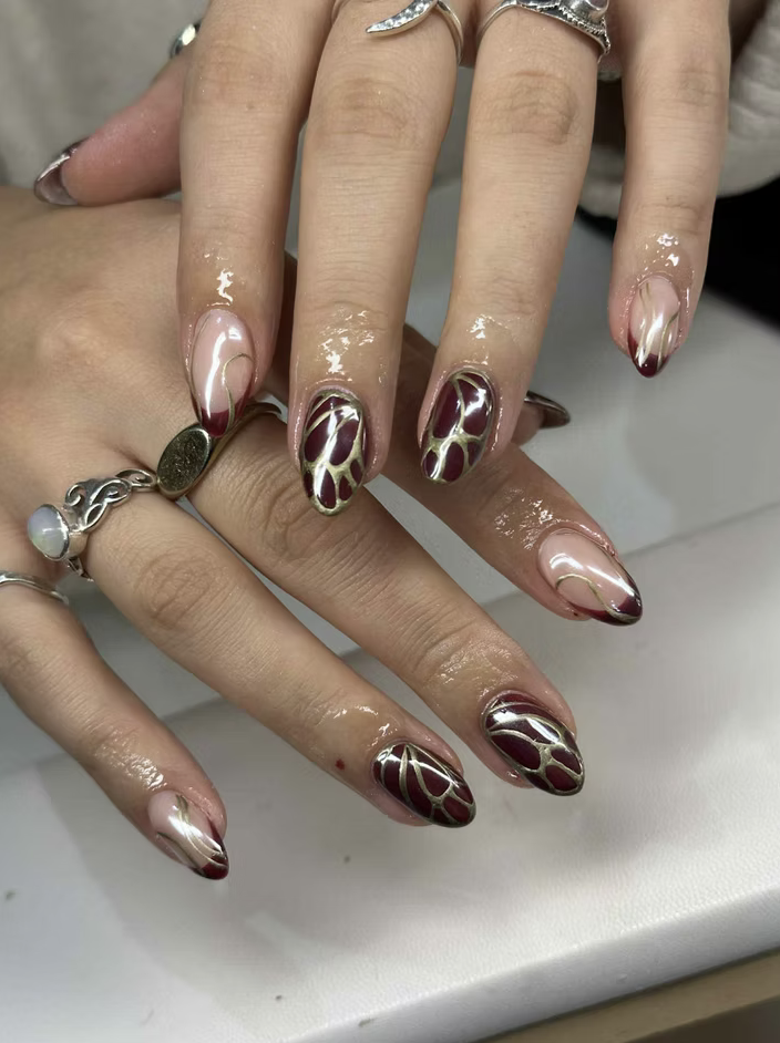 Burgundy and chrome hand-painted nail art