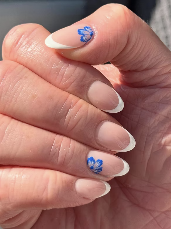 Soft French manicure with blue floral accent nails
