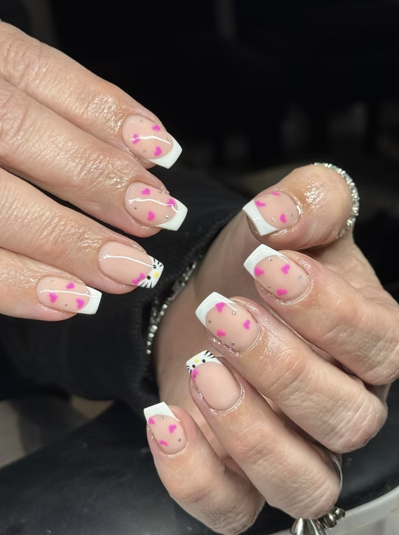 White French tips with pink hearts and crystal detail